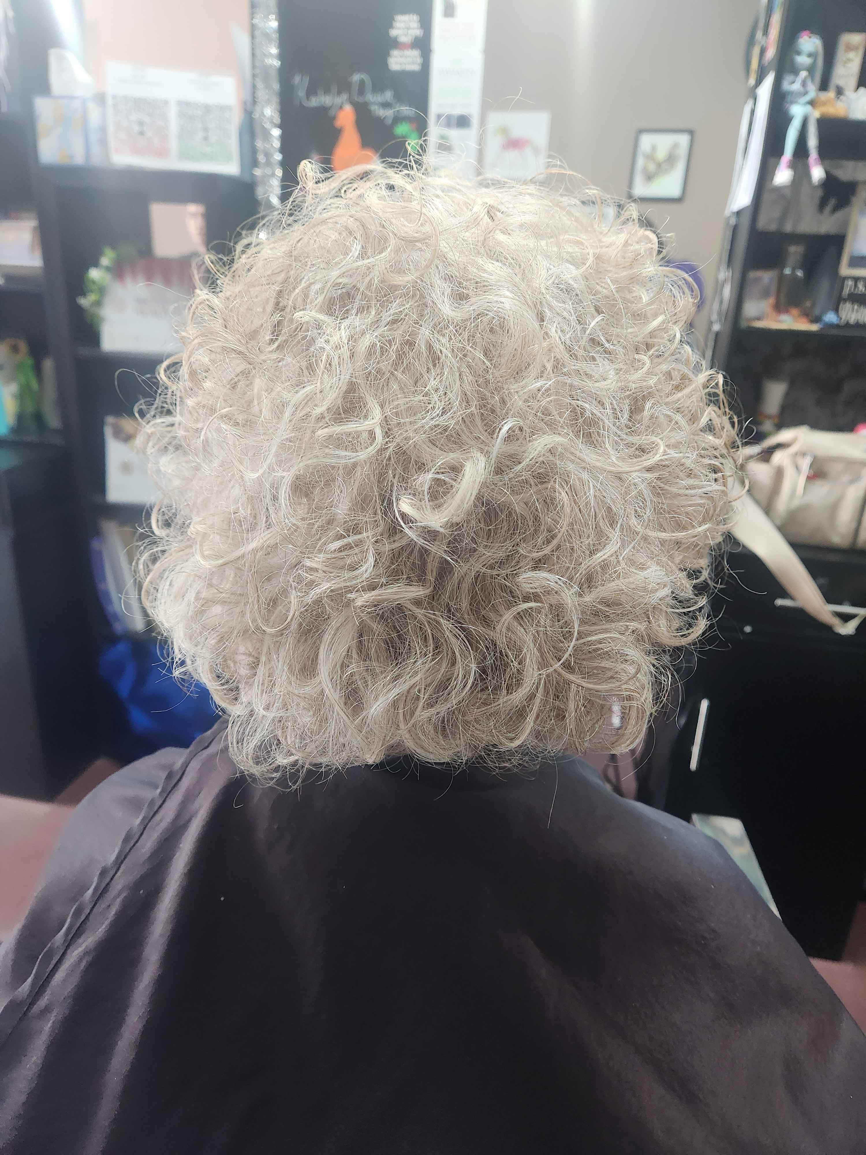 a client with above the shoulder natural white-grey curly hair